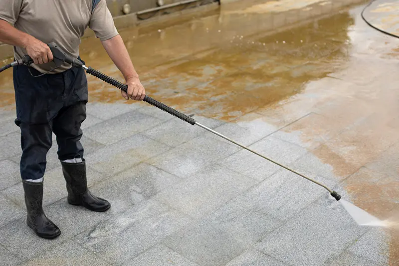 pressure washing red dirt away from a surface